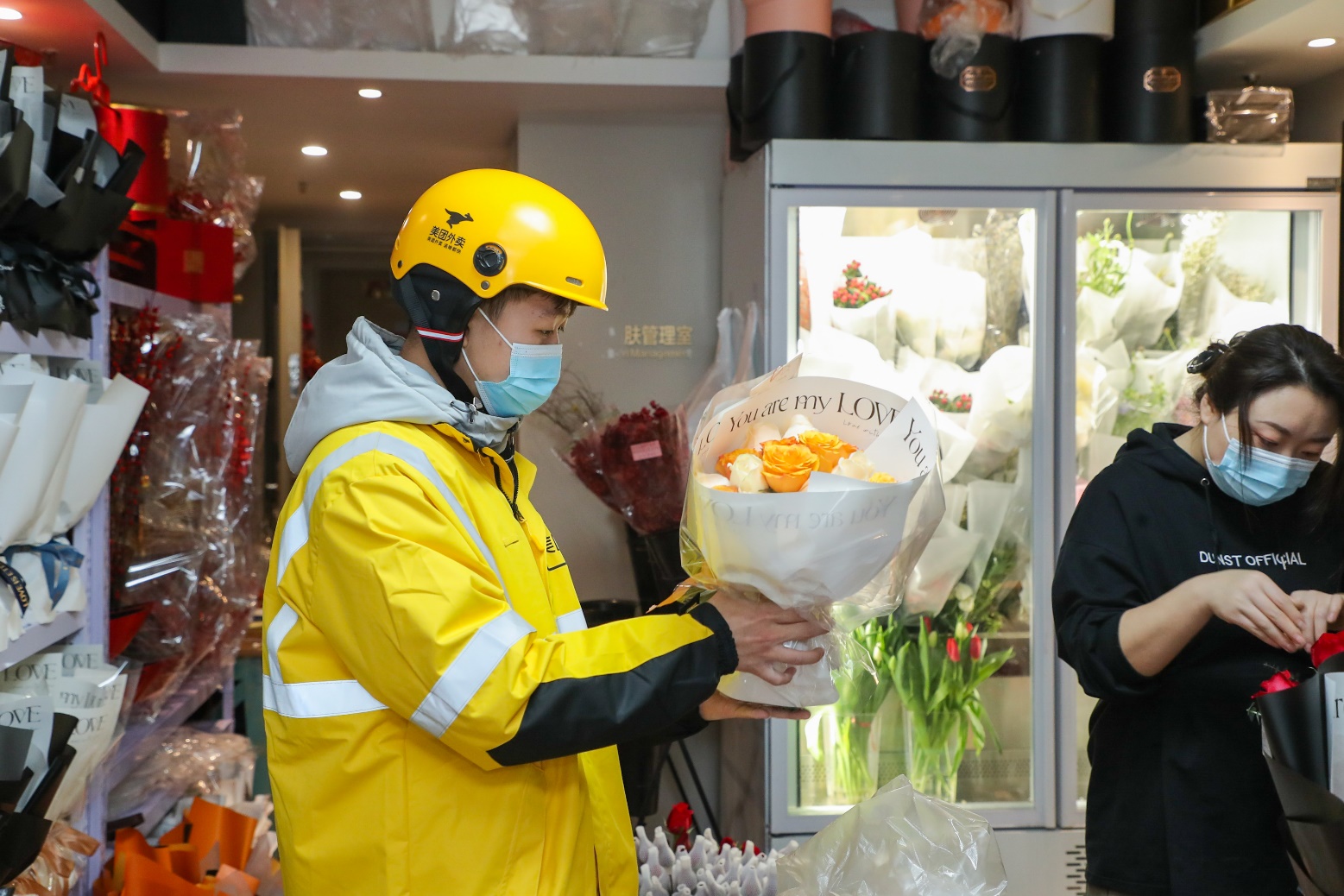 ▲情人節(jié)期間，外賣(mài)員在花店取鮮花訂單。（攝影：李鳴）